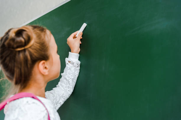 fille écrivant sur un tableau d'école